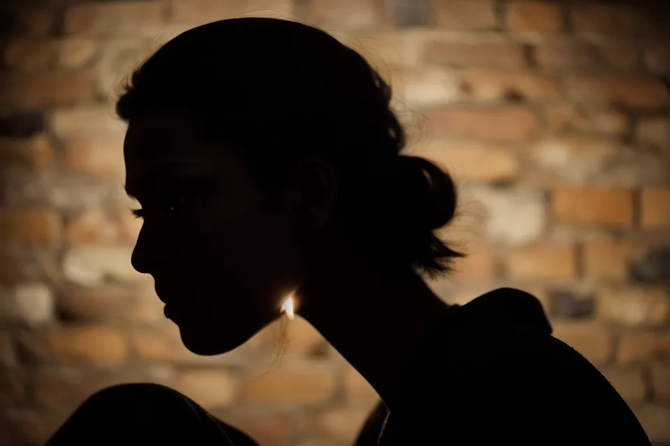 Silhouette of a woman comparing four different soulmate sketches on a wall